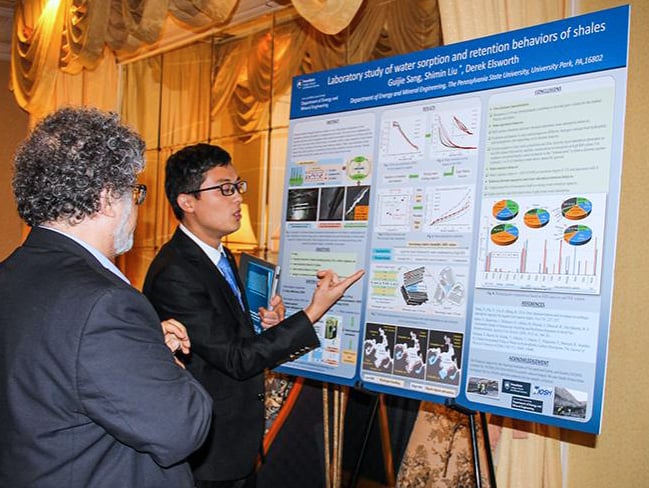 Guijie Sang stands in front of a technical poster explaining the content for his poster, Laboratory study of water sorption and retention behaviors of shales.