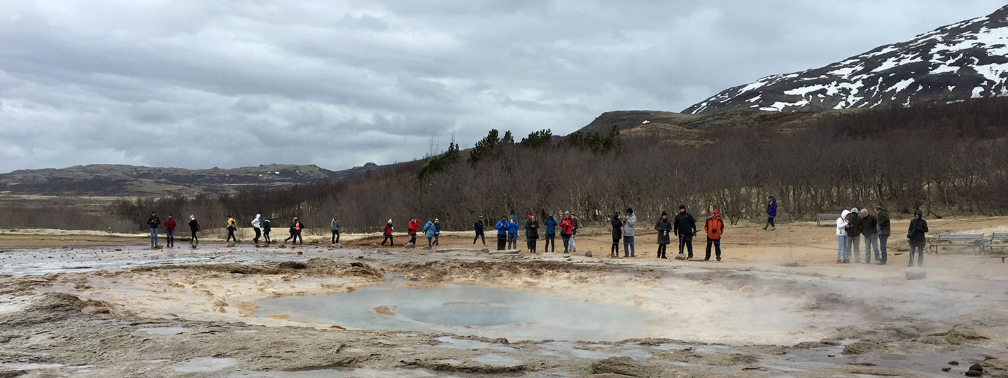 G3 students gather in front of a steamy pond on a field excursion to witness a geyser.