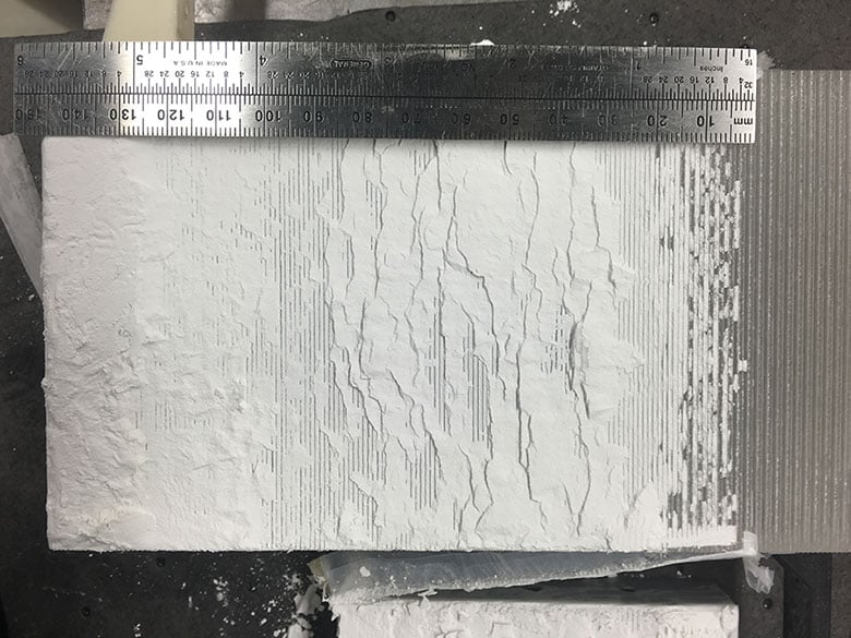 A ruler stis on top of a sediment sample to show the scale of a laboratory experiment in the Rock and Sediment Mechanics Laboratory.